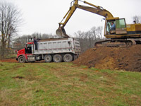 Excavator loading truck - Farm Dump Cleanup & Soil Replacement