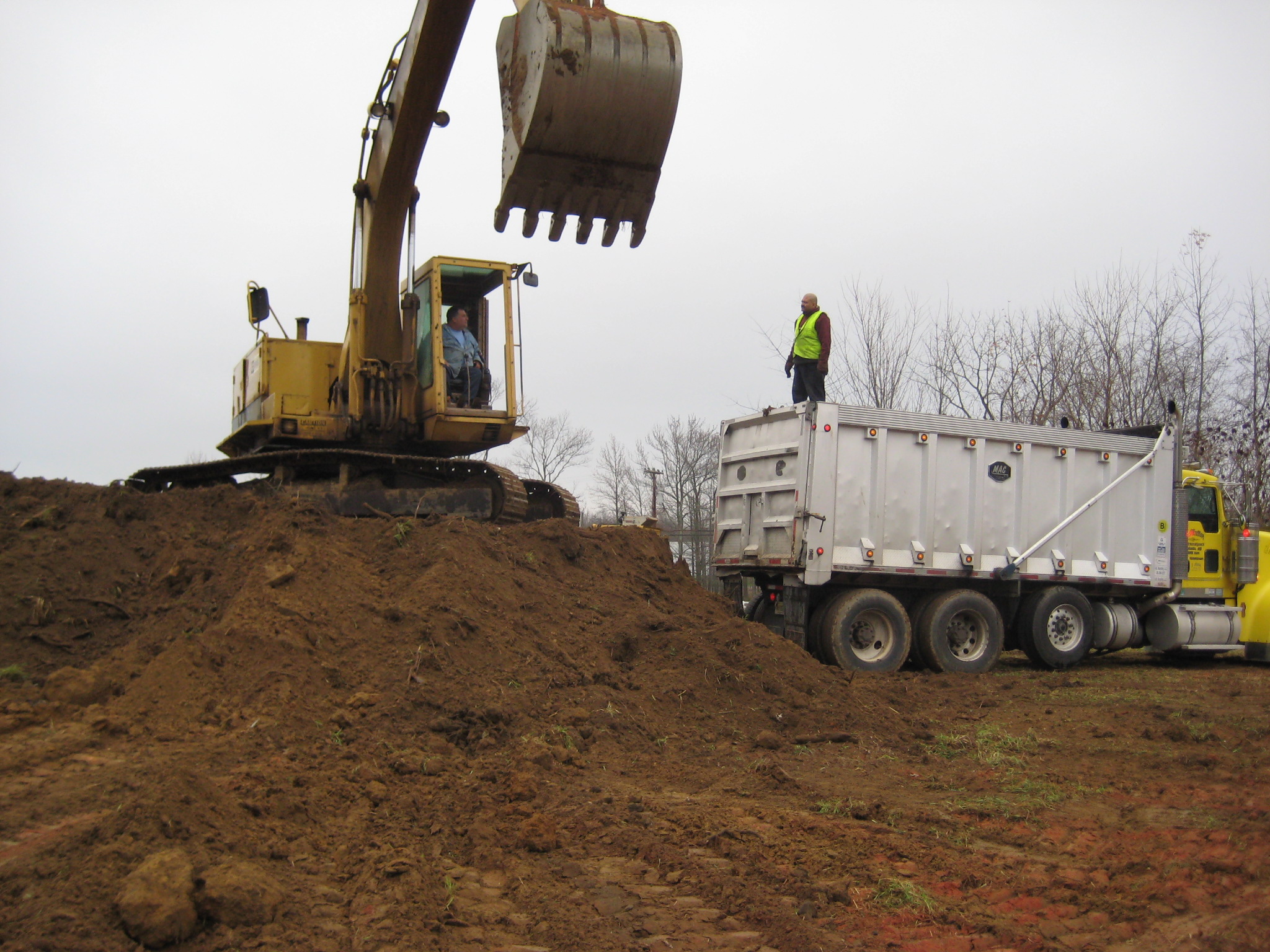 Excavator loading truck - Farm Dump Cleanup & Soil Replacement